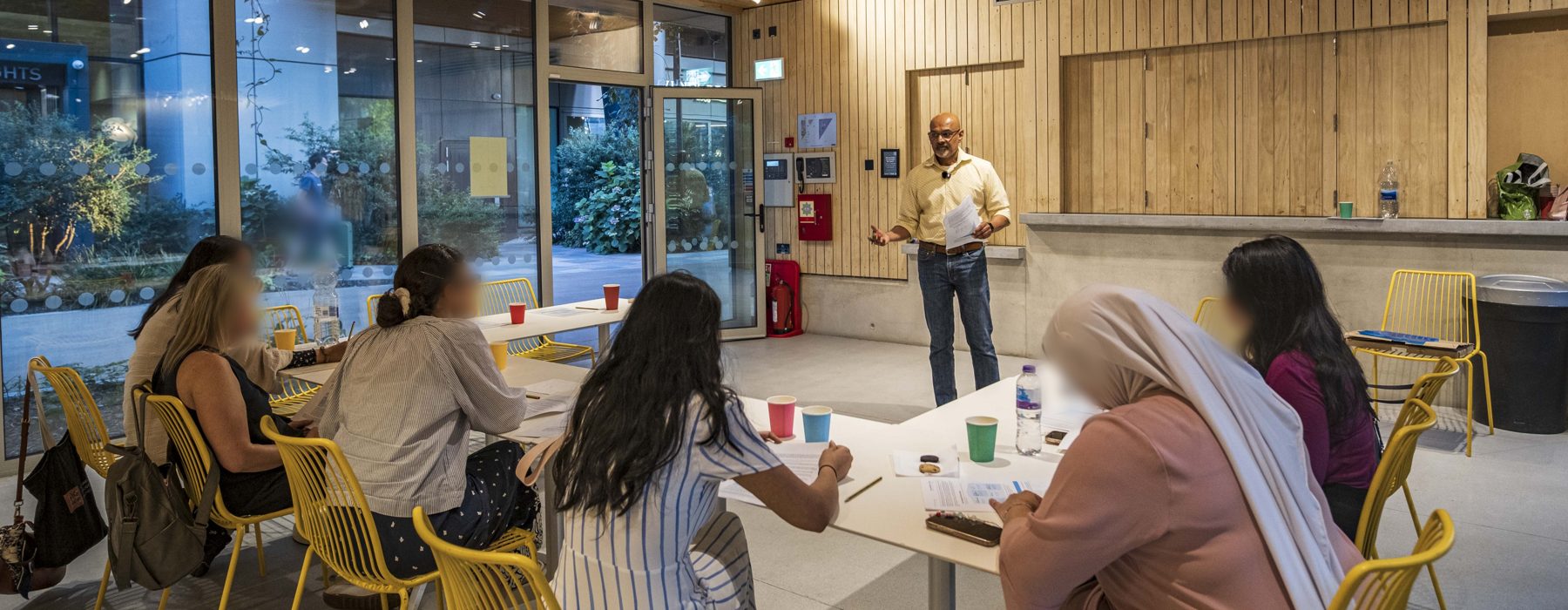 A community group at a find your point financial education evening, gathered around tables in a hall